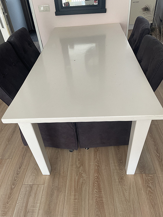 Mooie witte eettafel met 4 bruine suède stoelen op wieltjes